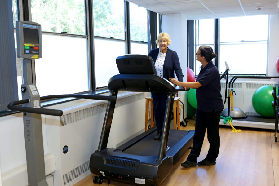 Patient with therapist on walking machine