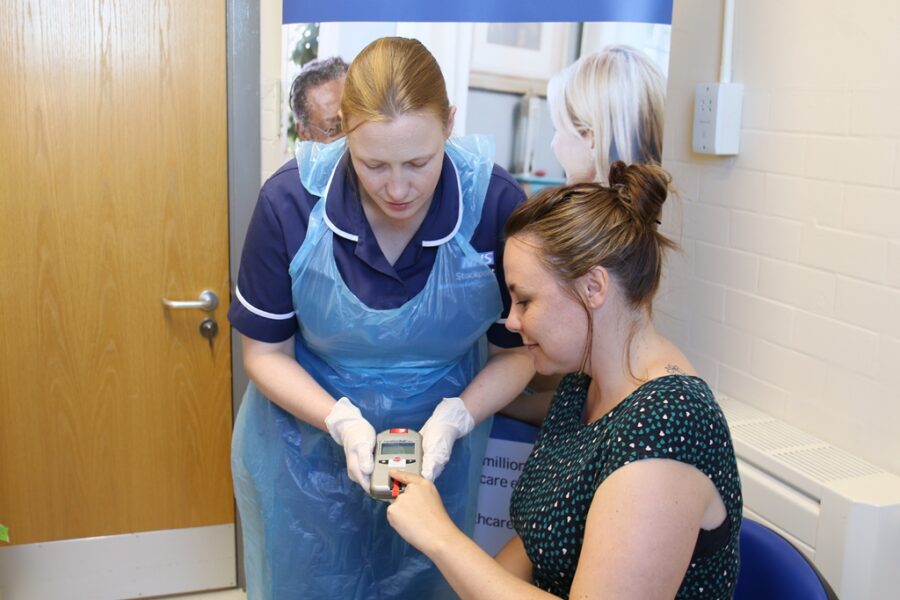 Woman taking part in medical research with research nurse