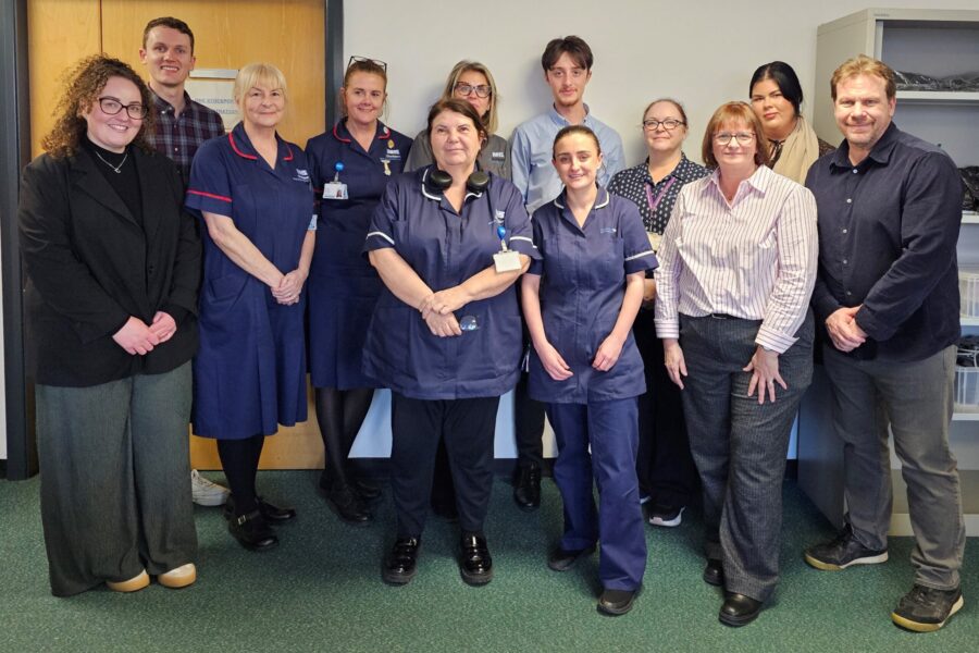 A group of NHS staff, some in nursing uniform